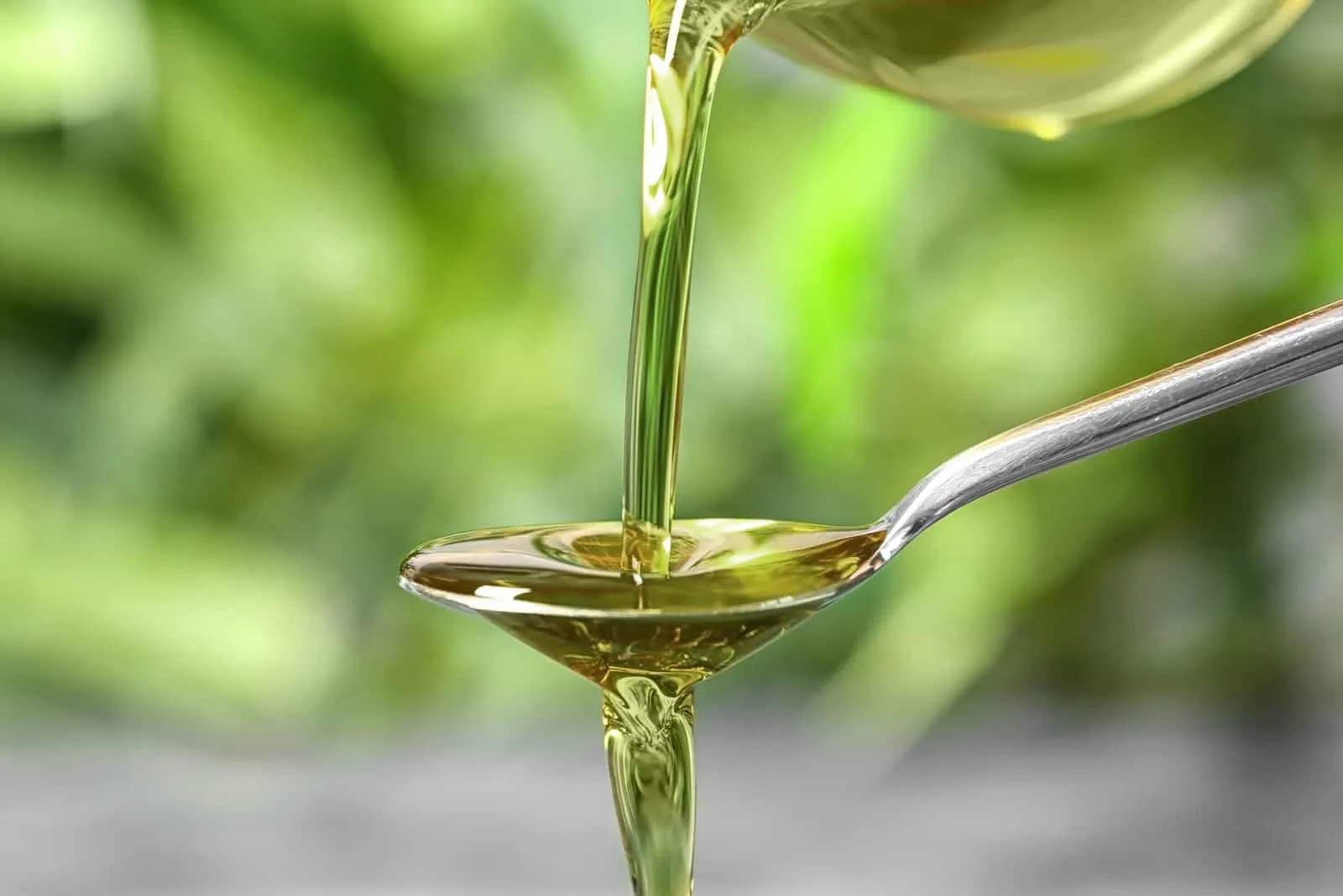 frisches Olivenöl wird mit einem Löffel gegossen