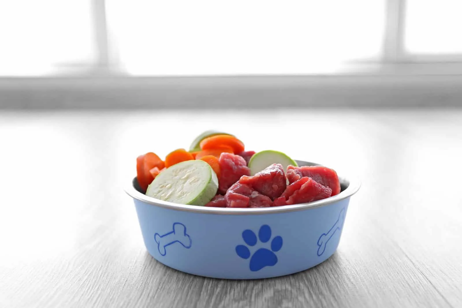 Bio-Hundefutter in einer Schüssel auf einem Holzboden