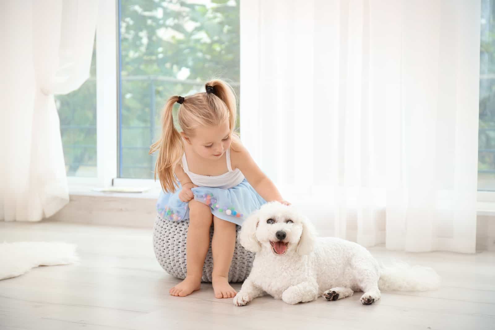 Entzückendes kleines Mädchen mit ihrem Hund zu Hause