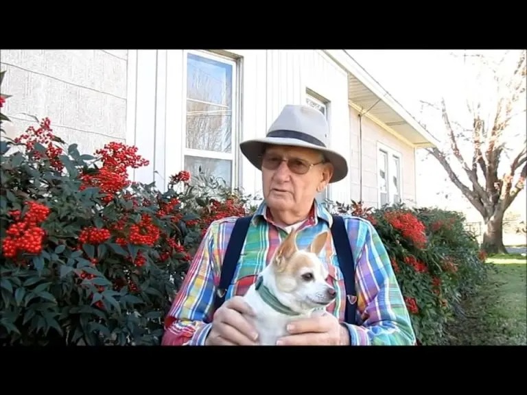 Ein aelterer Mann mit einem Hund im Schoß
