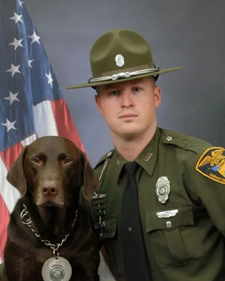 Hund und Polizeibeamter posieren