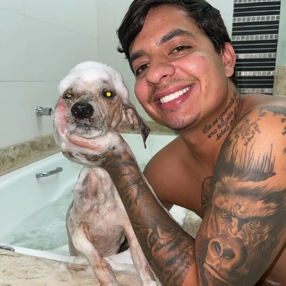 Mann gibt Hund sein erstes Bad