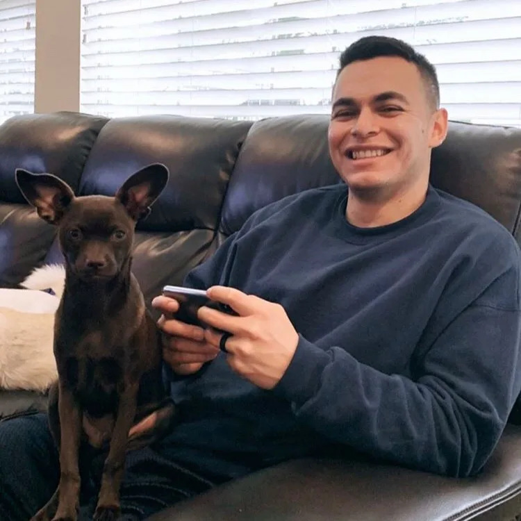 gluecklicher Mann mit Hund auf der Couch