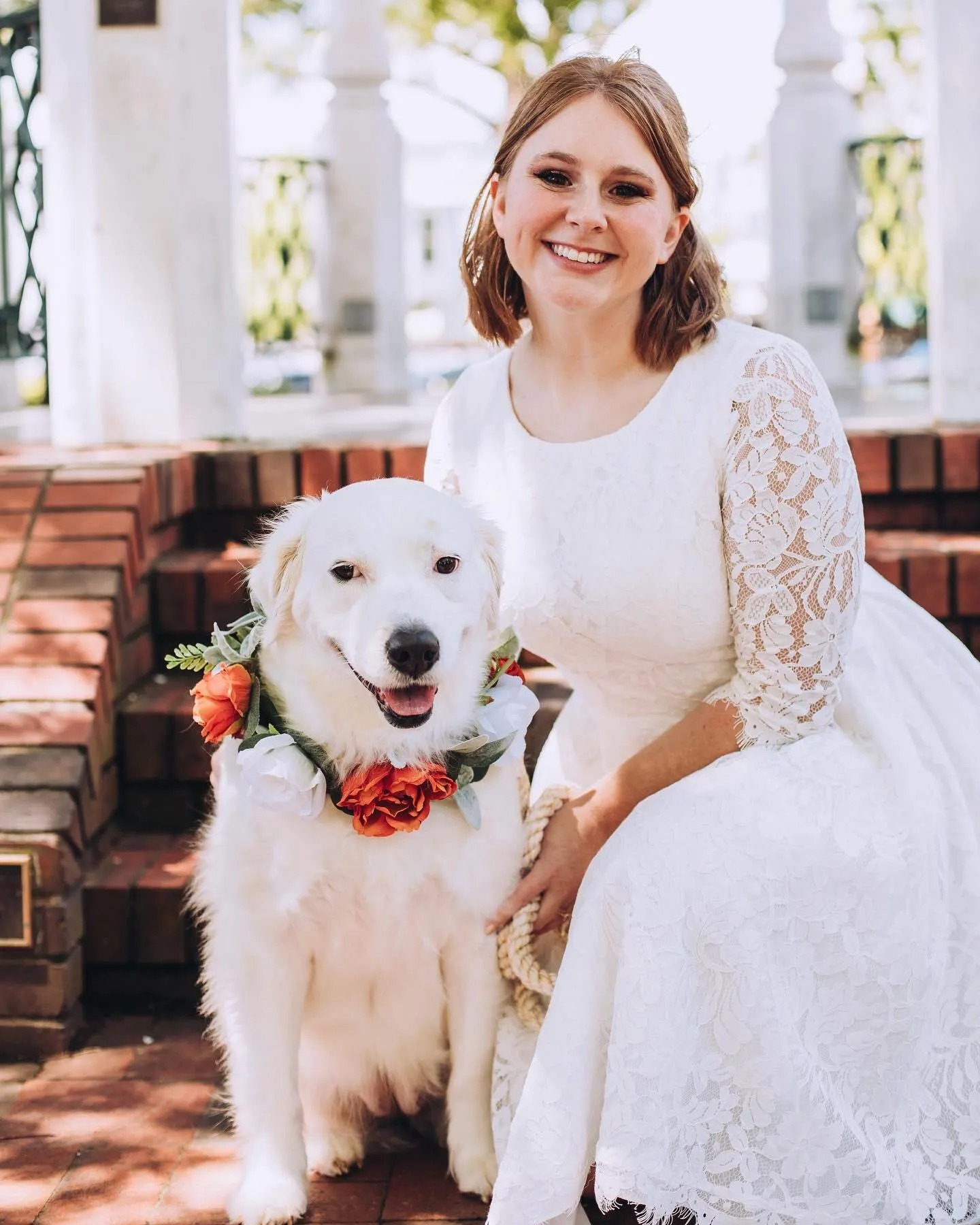 Eine Frau im Hochzeitskleid mit ihrem Hund