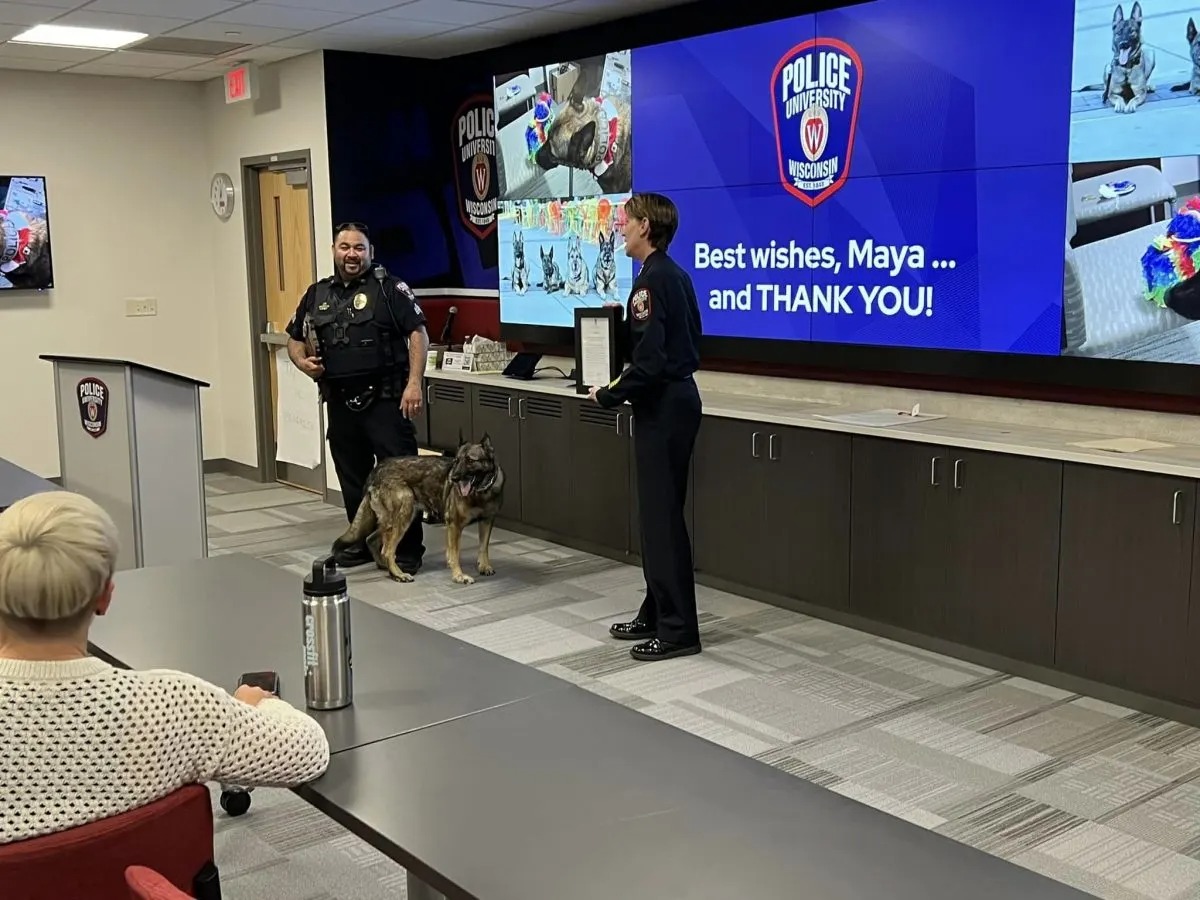 Hund Maya steht zwischen zwei Polizisten
