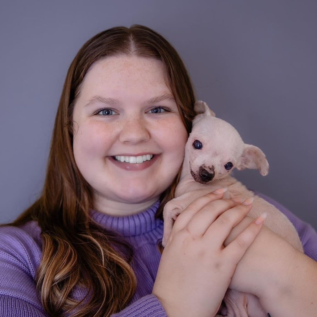 Frau mit kleinem Hund im Arm