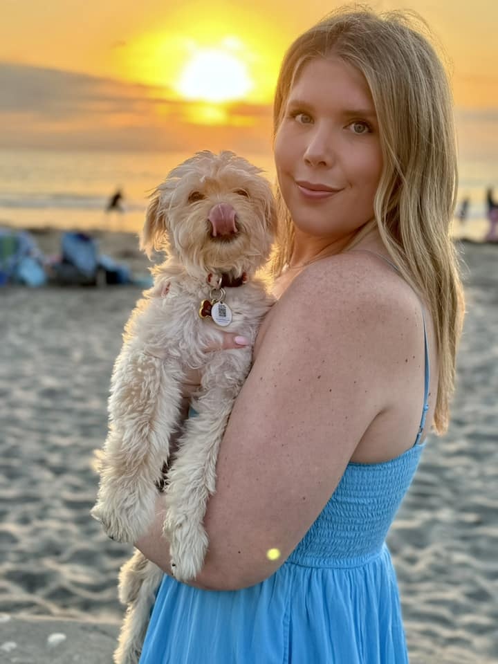 Hund mit Frau am Strand